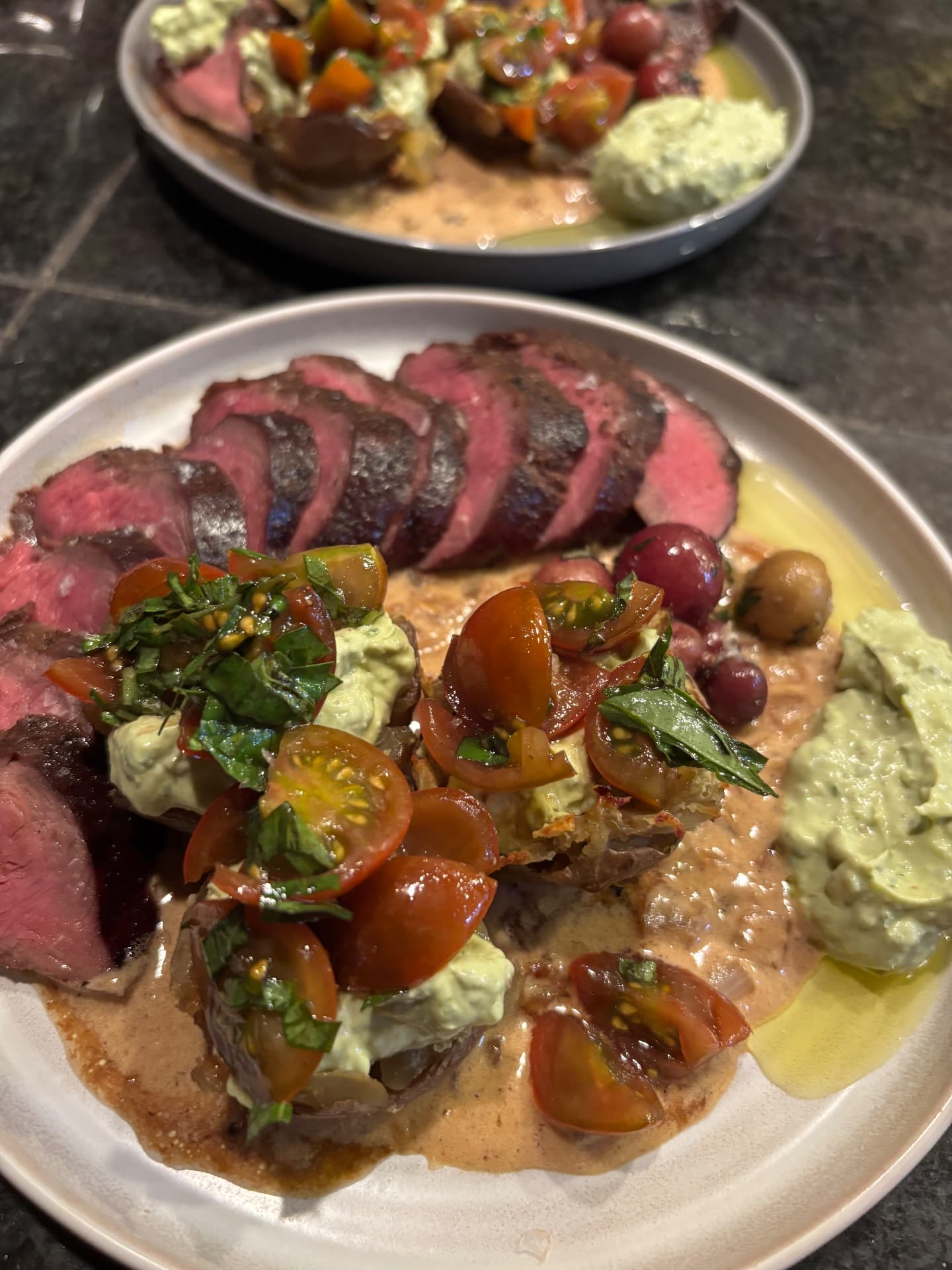 Sliced steak with tomatoes and herb butter